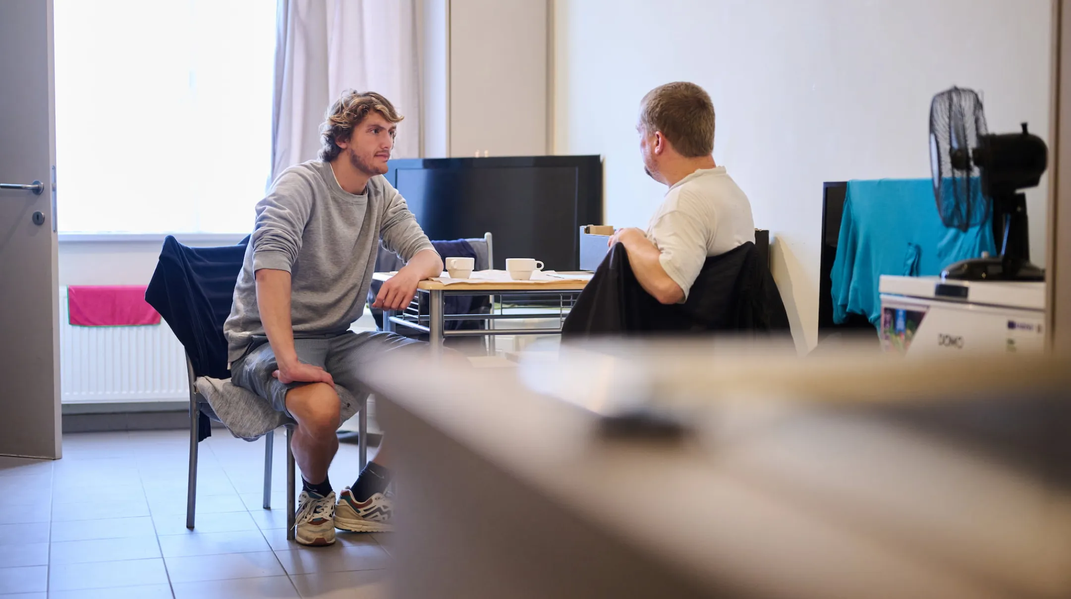 Hulpverlener in gesprek met persoon in crisiswoning